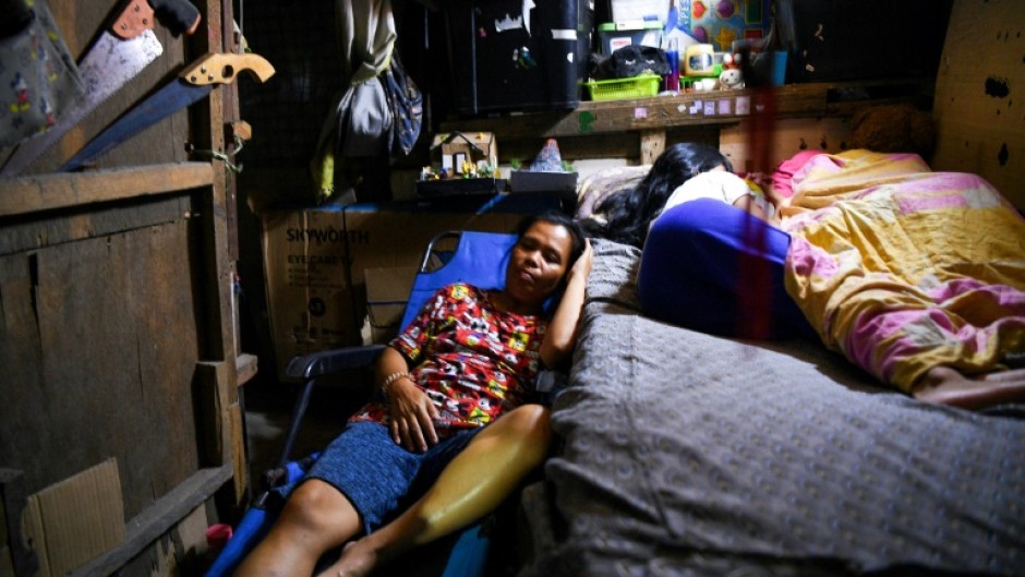 Richel Mangampo (L) sleeps beside her children Jalian and Sherwin at their house in Manila 