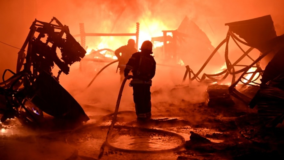 Firefighters try to douse a blaze sparked by a Russian drone attack