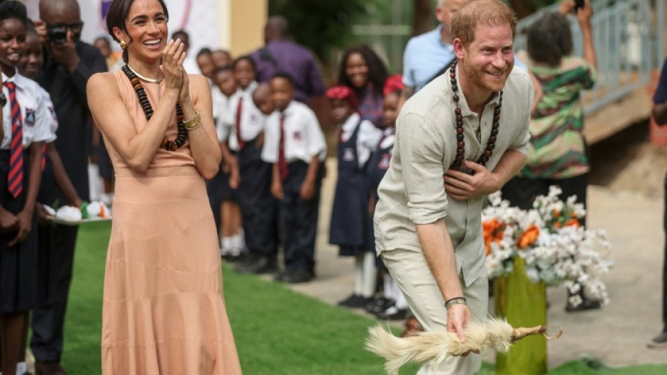 Britain's Prince Harry and his wife Meghan vist a school in Abuja to open an event on mental health for students