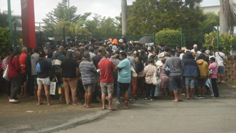 People queue outside a supermarket in New Caledonia's Noumea