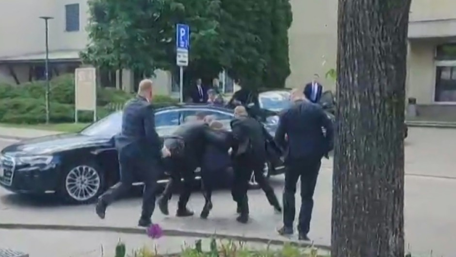 Security men help Slovakia's wounded Prime Minister Robert Fico to his car