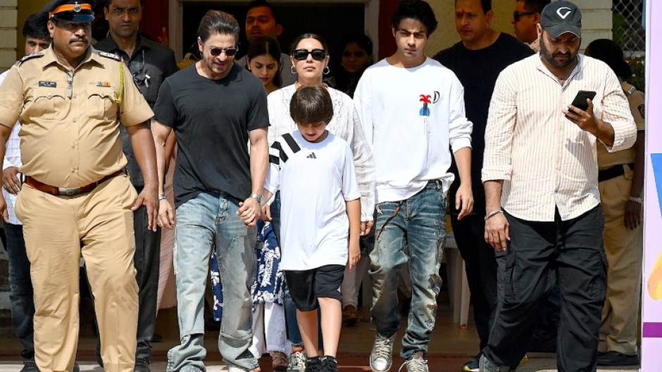 Bollywood actor Shah Rukh Khan (4L) along with his family leaves a polling booth after casting his ballot vote in Mumbai