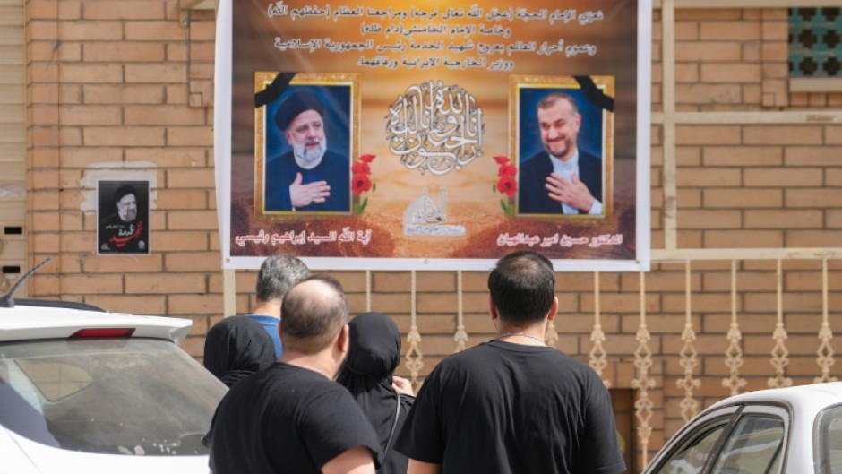 Portraits of Iran's President Ebrahim Raisi, on the left, and Foreign Minister Hossein Amir-Abdollahian on a wall in the central Iraqi holy city of Najaf