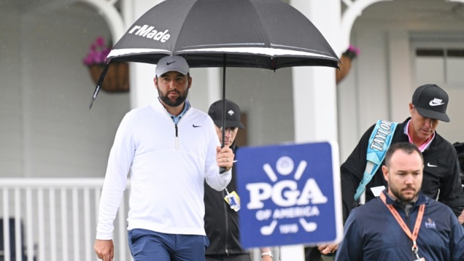 Scottie Scheffler (L) and caddie Ted Scott walk to the driving range on Friday after his arrest and release before round two of the PGA Championship