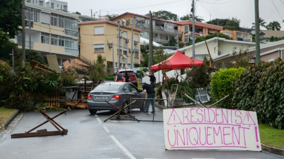 A sign at a roadblock in Portes de Fer district reads 'Residents only!' as a car is checked