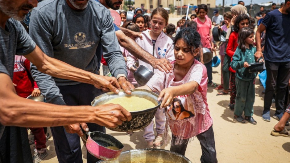 Displaced Palestinian children line up to receive food in southern Gaza's Rafah