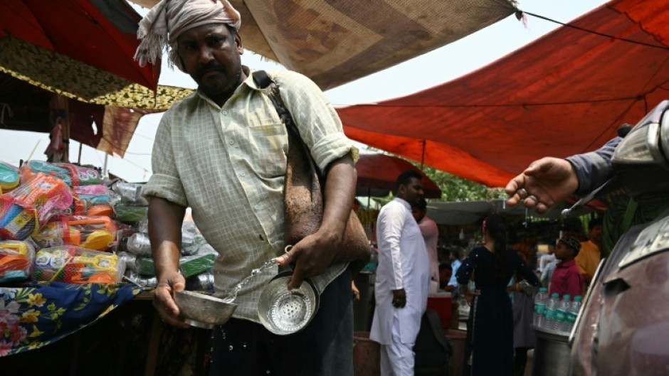 A volunteer distributes water during a hot summer day in Delhi on May 17