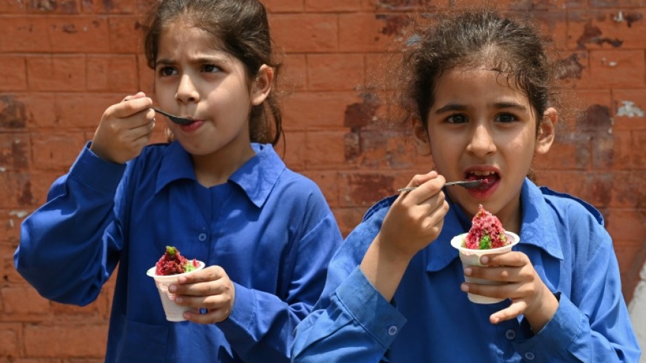 Students eat ice cream outside their school in Lahore, the capital city of Pakistan's Punjab province, where schools will close a week early because of extreme temperatures