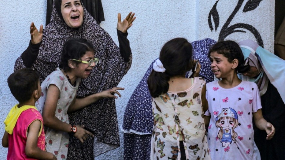 Palestinians react to an Israeli strike on a building in Nuseirat on May 25, 2024