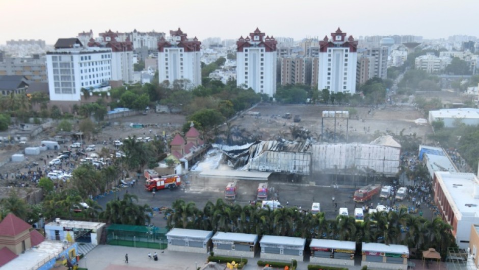 This aerial photograph taken on May 25, 2024 shows firefighters trying to extinguish a fire which broke out at an amusement park facility in Rajkot, in India's Gujarat state