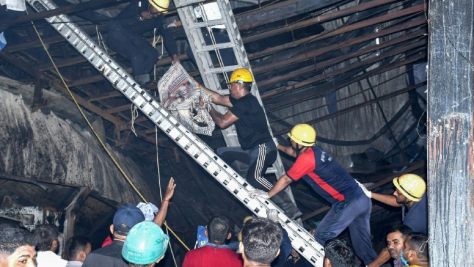 Rescue workers carry a victim after a fire broke out at an amusement park facility in Rajkot, in India's Gujarat state