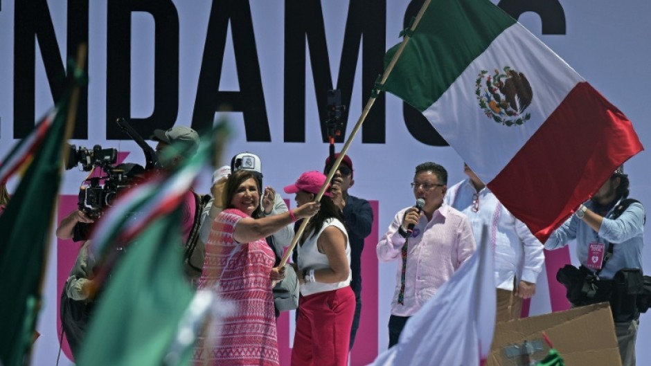 Opposition presidential candidate Xochitl Galvez waves the Mexican flag at a rally in the capital