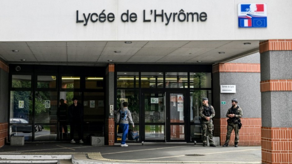 French gendarmes stand guard outside a high school in the western town of Chemille-en-Anjou, where a teacher was stabbed by pupil 