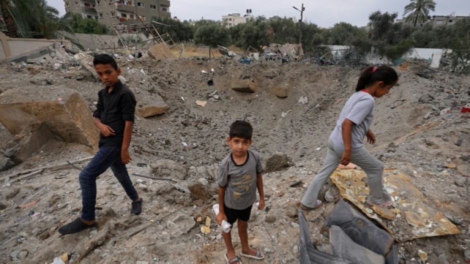 Palestinian children near the crater left by an Israeli strike in Nuseirat in the central Gaza Strip on June 3, 2024