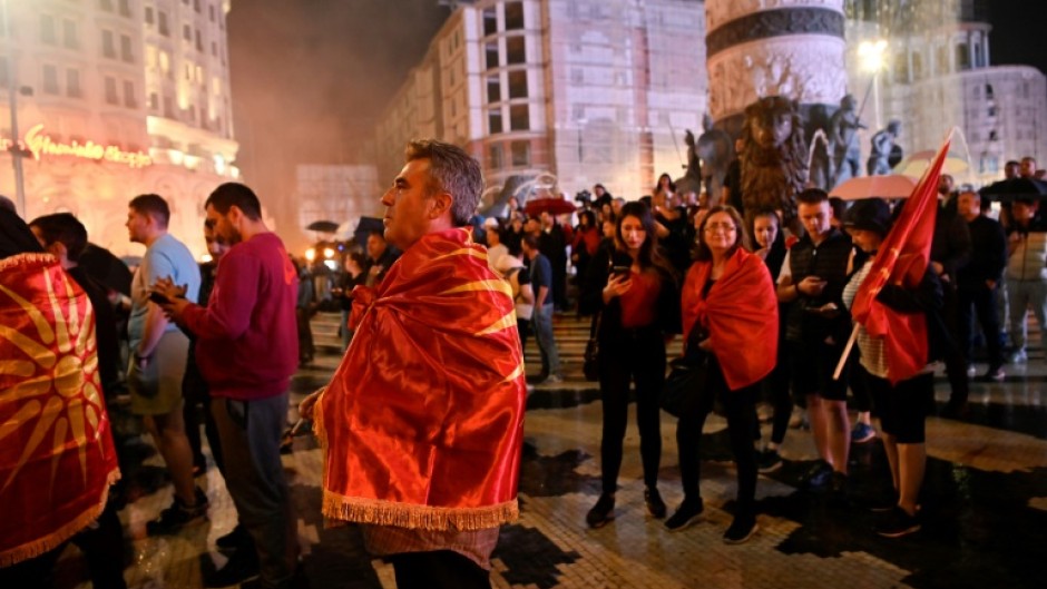 VMRO-DPMNE supporters wrapped in nationalist flags gather to celebrate their party's victory in North Macedonia's elections