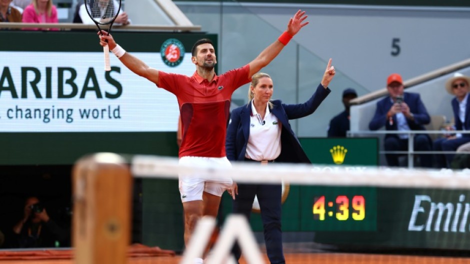 Serbia's Novak Djokovic (L) celebrates the winning point of his five-set victory over Francisco Cerundolo