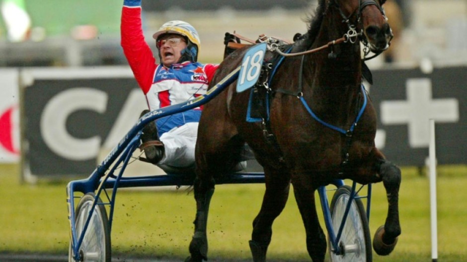 (FILES) Italian jockey Giampaulo Minucci celebrates his victory as he drives trotter 'Varenne' during the Prix D'Amerique legend race at Vincennes racetrack, outside Paris, on January 27, 2002