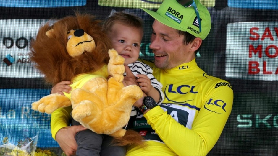 Primoz Roglic celebates his overall victory in the Criterium du Dauphine with his child on the podium