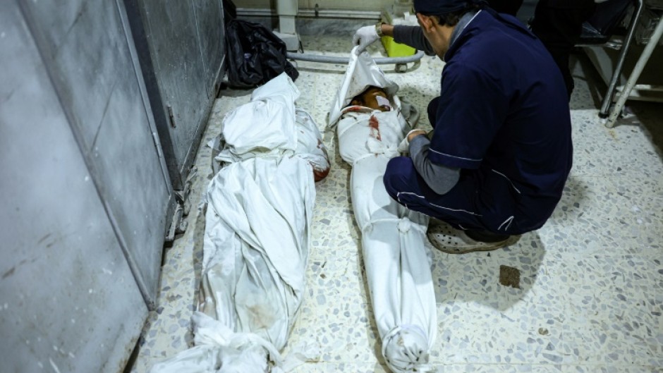 A medical worker covers a body at the hospital in Idlib