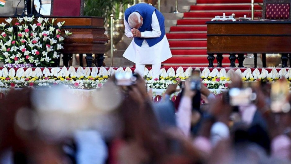 India’s newly sworn-in Prime Minister Narendra Modi bows his head to the crown after taking the oath of office for his third term