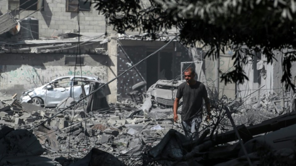 A Palestinian looks at the debris from fighting following the hostage rescue operation by Israeli special forces in Nuseirat camp, central Gaza, on June 8, 2024