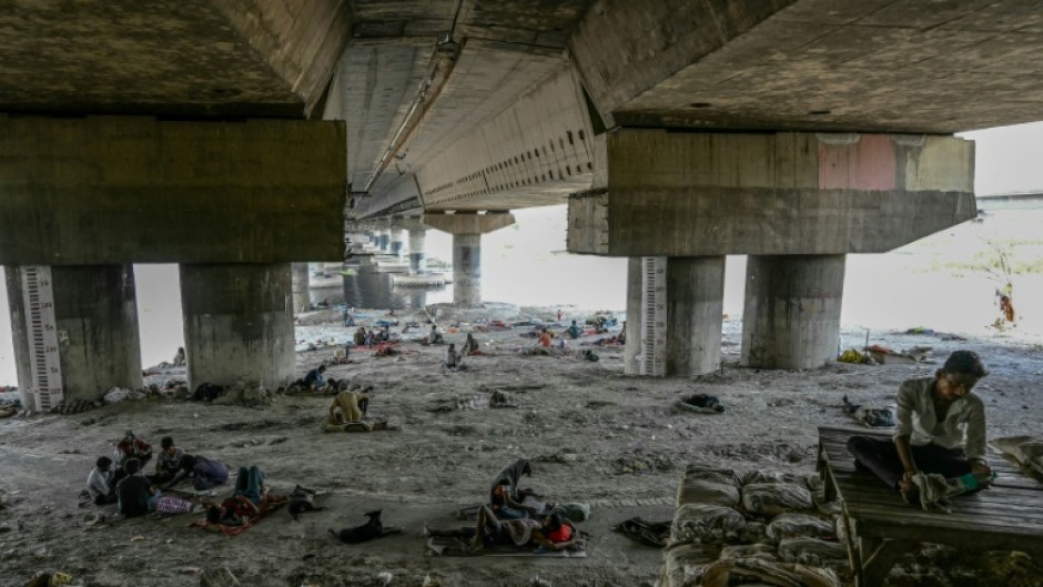 Homeless people are seen resting under a flyover to escape a searing heatwave in New Delhi on May 31