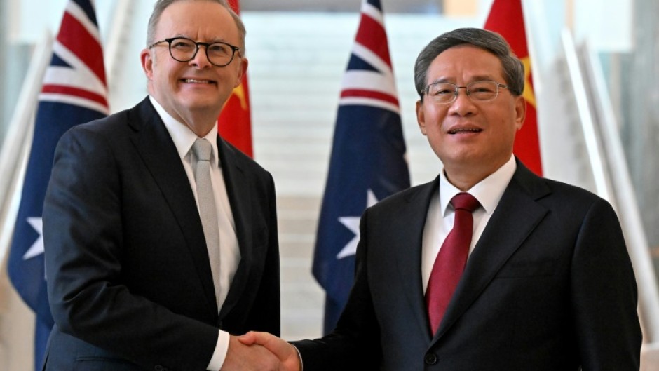 Prime Minister Anthony Albanese (L) shakes hands with Premier Li Qiang, the highest-ranking Chinese official to visit Australia in seven years