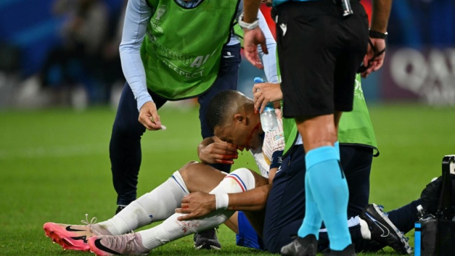 Kylian Mbappe receives medical treatment after breaking his nose during France's 1-0 win against Austria at Euro 2024