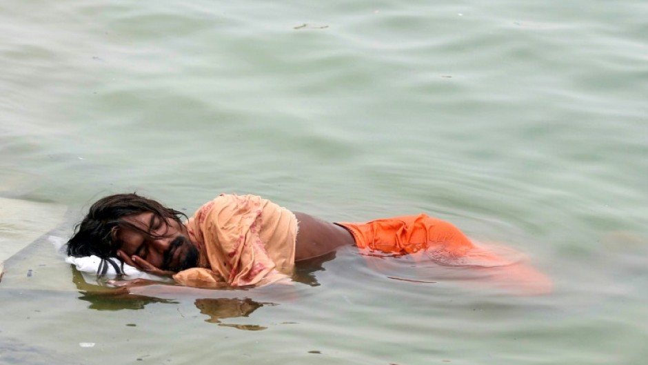 A man in India sleeps in the River Ganges in Varanasi on June 18: much of northern India has been gripped by a brutal month-long heatwave