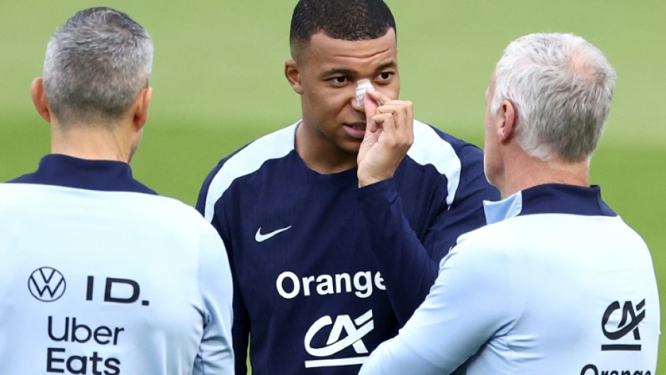 Kylian Mbappe, with a plaster on his broken nose, speaks to France coach Didier Deschamps at the team's Euro 2024 base in Paderborn on Wednesday