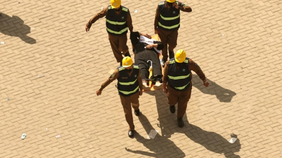 Rescuers carry away a man on a stretcher in Mina amid scorching temperatures