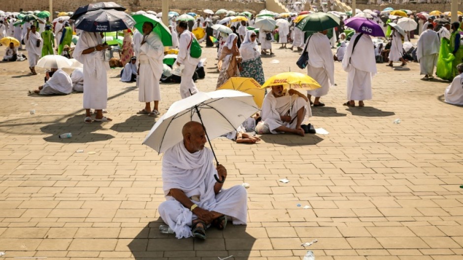 Muslim pilgrims use umbrellas to shade themselves from the sun as they arrive at the base of Mount Arafat during the hajj