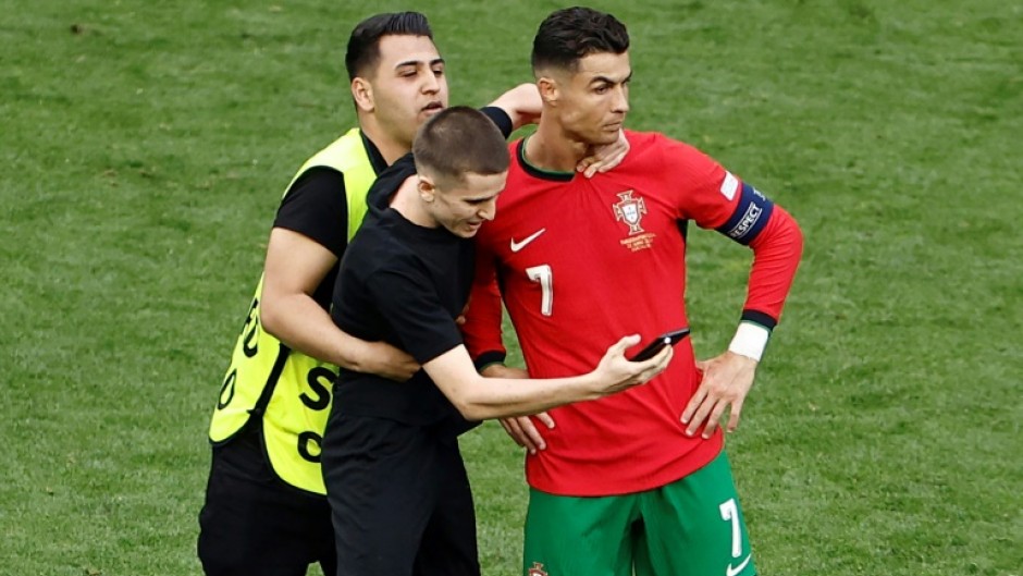 A pitch invader takes a selfie with Cristiano Ronaldo 