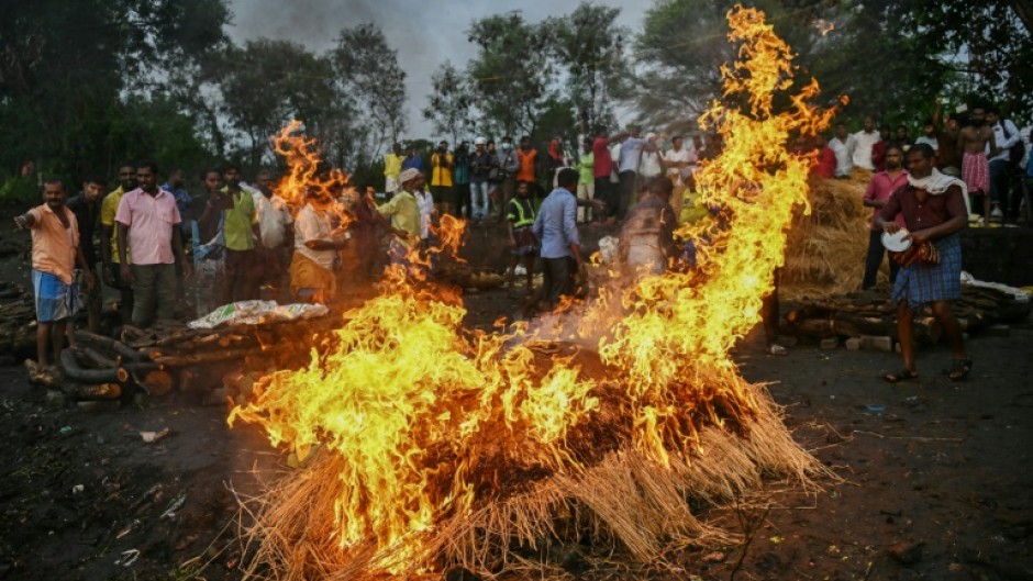 Family members perform last rites during the funeral of victims who died after consuming toxic alcohol 