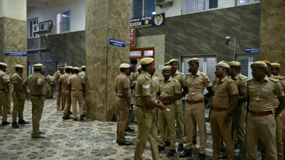 Indian police stand guard in front of a hospital ward caring for patients who consumed toxic illegal alcohol in Tamil Nadu state