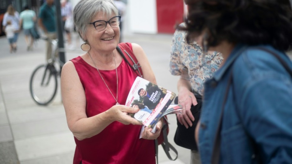 An activist with France's New Popular Front left-wing alliance distributes leaflets in the southern French city of Marseille 