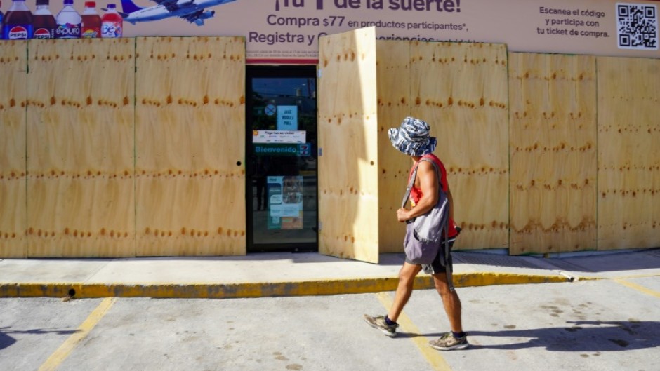 A man walks past a boarded-up store in Tulum, Quintana Roo State, Mexico