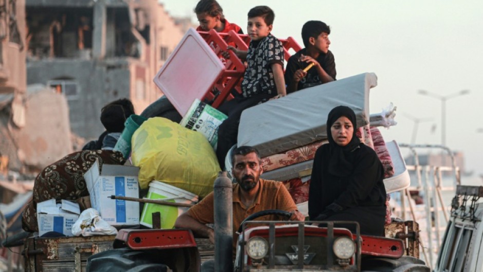 Displaced Palestinians leave an area of Khan Yunis after the Israeli army issued a new evacuation order, which the UN called the largest since the Israel-Hamas war began