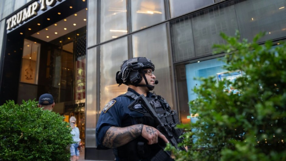 Law enforcement stand guard outside of Trump Tower in New York City after the rally shooting