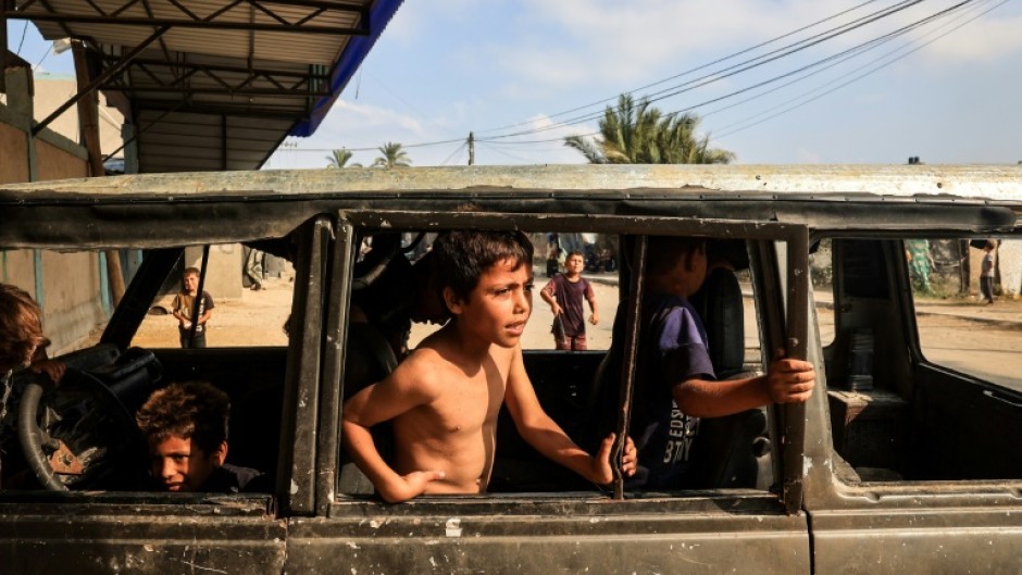 Displaced children play in a burned out vehicle in Deir al-Balah city, central Gaza 