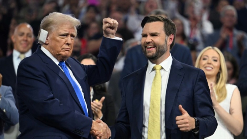 Republican vice presidential candidate J.D. Vance (R) shakes hands with Donald Trump during the second day of the 2024 Republican National Convention