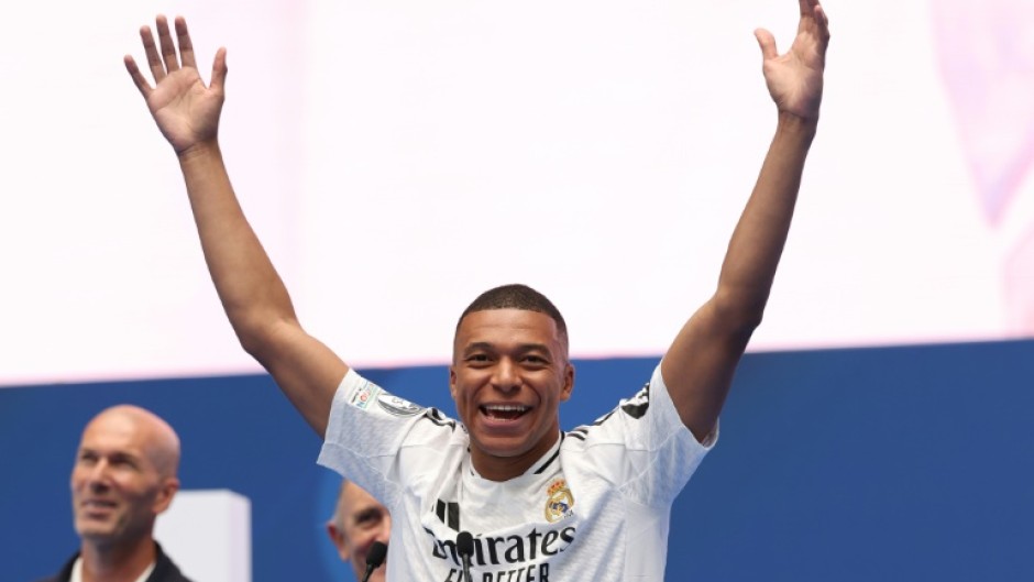 Kylian Mbappe salutes the Real Madrid fans as a former French hero at the club, Zinedine Zidane, looks on