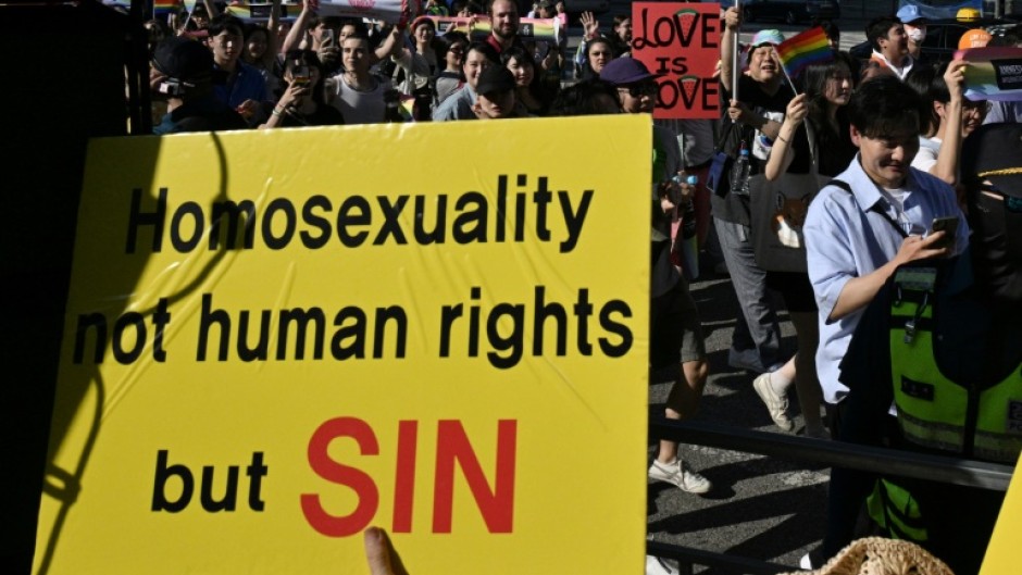 LGBTQ supporters march past anti-gay activists during the annual Pride Parade in Seoul in June