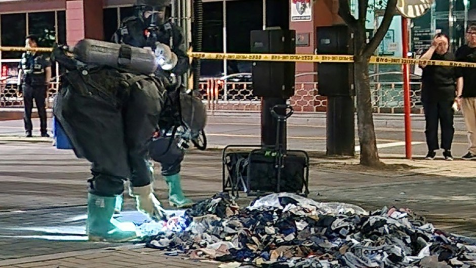 A South Korean Defence Ministry handout picture shows officers in Paju picking through trash sent by balloon from North Korea in early June 2024