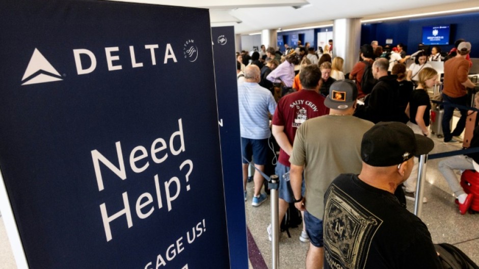 Travelers wait in line at the airport in Los Angeles, California on July 19, 2024 following a global IT crash that hobbled airlines, banks, broadcasters and other businesses