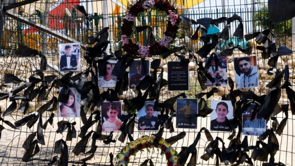 Portraits of the children and youngsters who were killed two days ago, hang on the football stadium fence where a rocket landed, in the Druze village of Majdal Shams in the Israeli-annexed Golan Heights