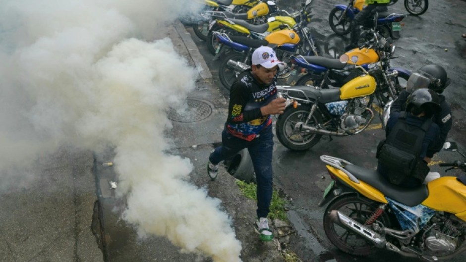 A demonstrator runs away from teargas during a protest against Venezuelan President Nicolas Maduro after he claimed victory in Sunday's election 