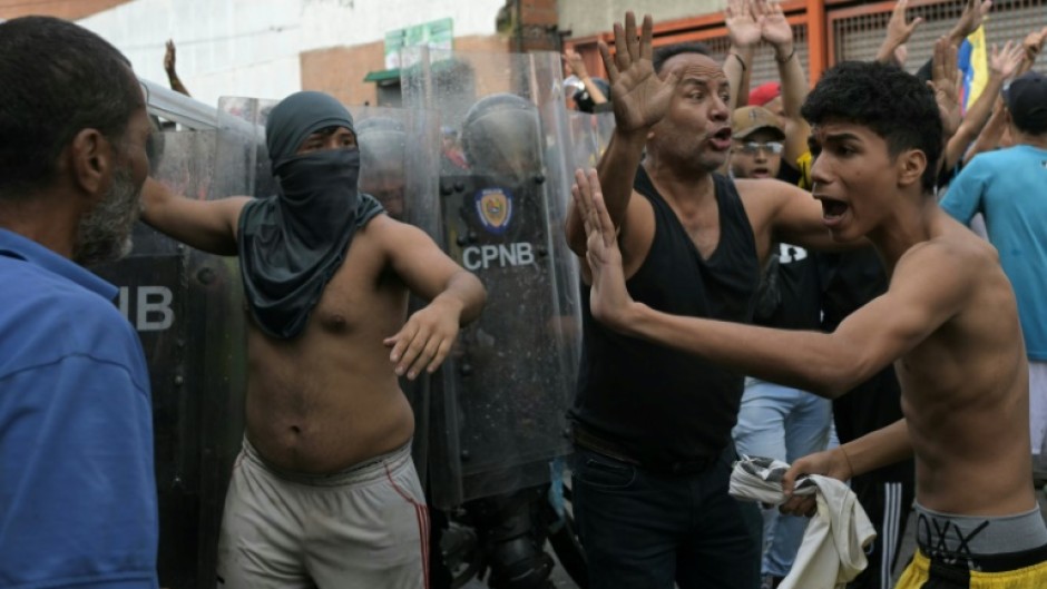 Demonstrators try to calm down among themselves as they clash with police officers during a protest against Venezuelan President Nicolas Maduro's government in Caracas on July 29, 2024