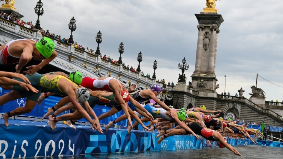 Triathletes dive into the River Seine at the start of the Olympic triathlon