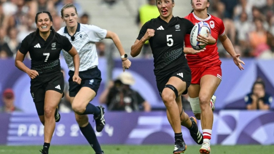 New Zealand's Sarah Hirini (2R) runs with the ball during the final victory over Canada